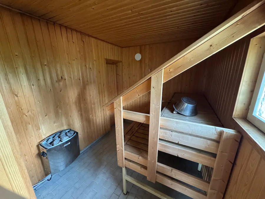 Puulämmitteisen tunnelman sauna — kiuas ja lauteet